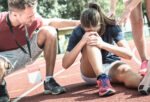 Female athlete holding knee after sports injury