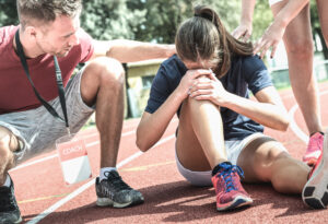 Female athlete holding knee after sports injury
