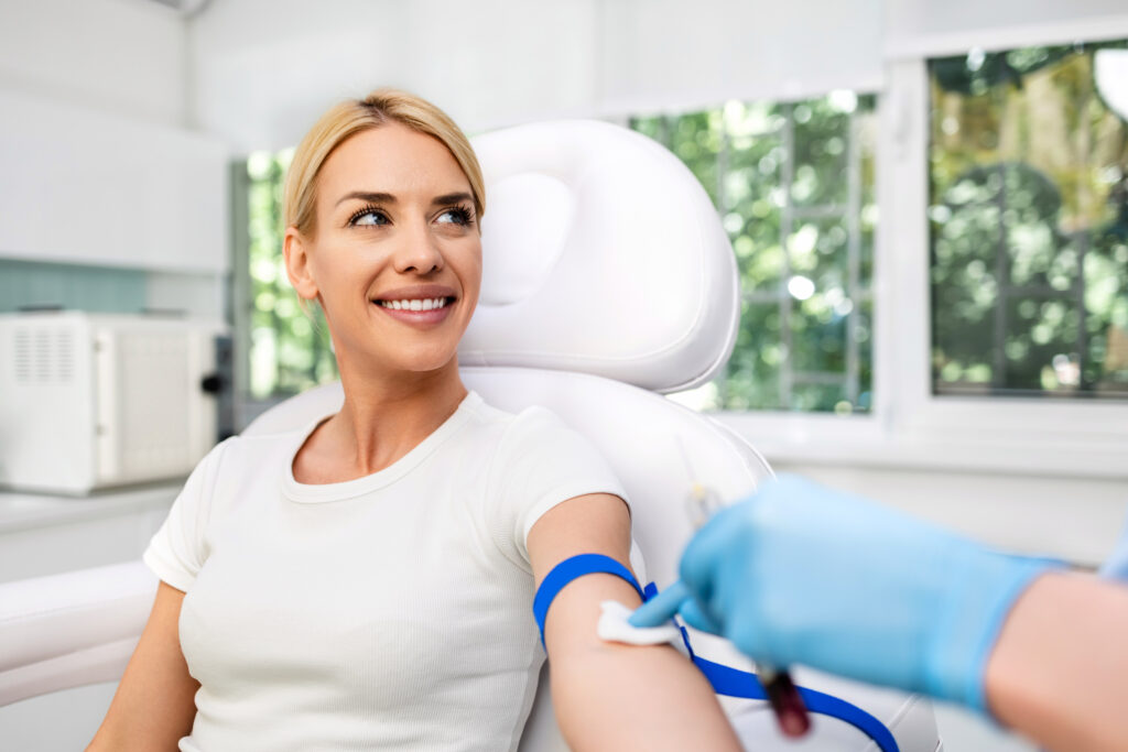 Blonde woman undergoing blood draw for platelet-rich plasma therapy to support pain relief.