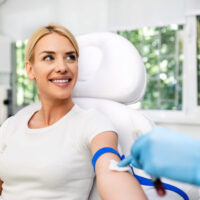 Blonde woman undergoing blood draw for platelet-rich plasma therapy to support pain relief.