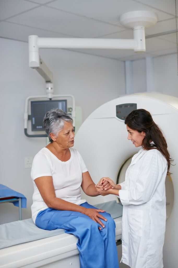 Accident injury doctor examining an older patient’s hand before a medical scan.