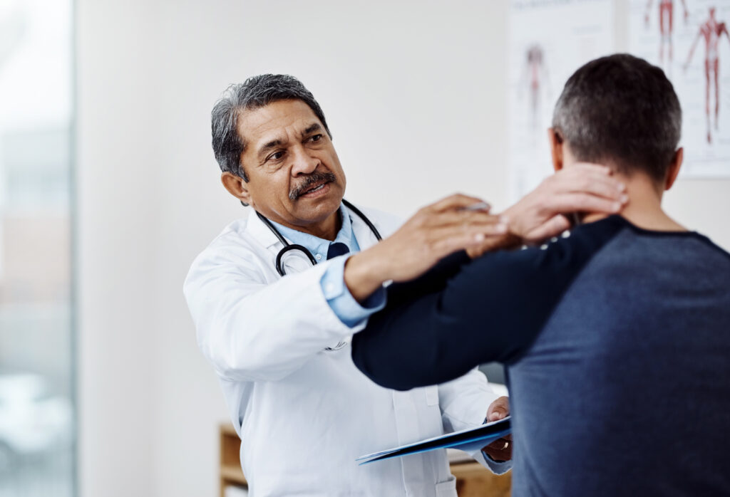 Doctor examining patient’s neck to recommend non-surgical neck pain treatment.