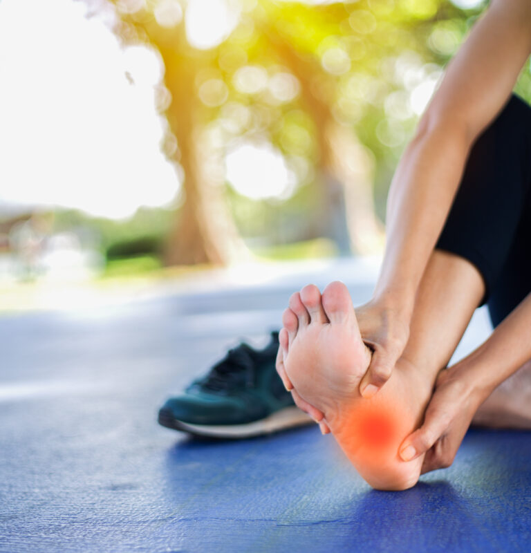 Person experiencing sudden foot pain without injury during exercise.