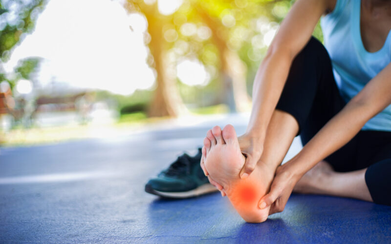 Person experiencing sudden foot pain without injury during exercise.