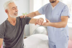 Senior man receiving physical therapy from a therapist during outpatient rehabilitation to improve strength and mobility after surgery