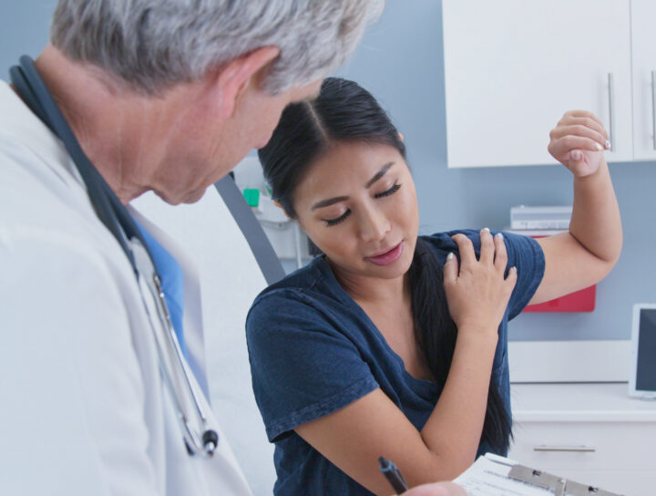 Patient discussing chronic back pain with doctor – chronic and acute pain explained.