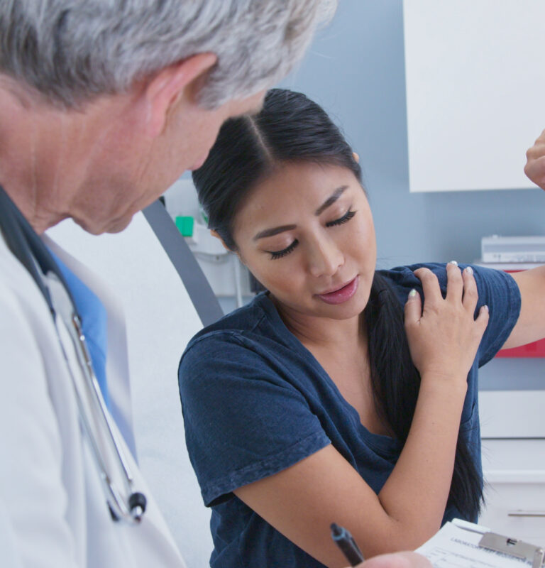 Patient discussing chronic back pain with doctor – chronic and acute pain explained.