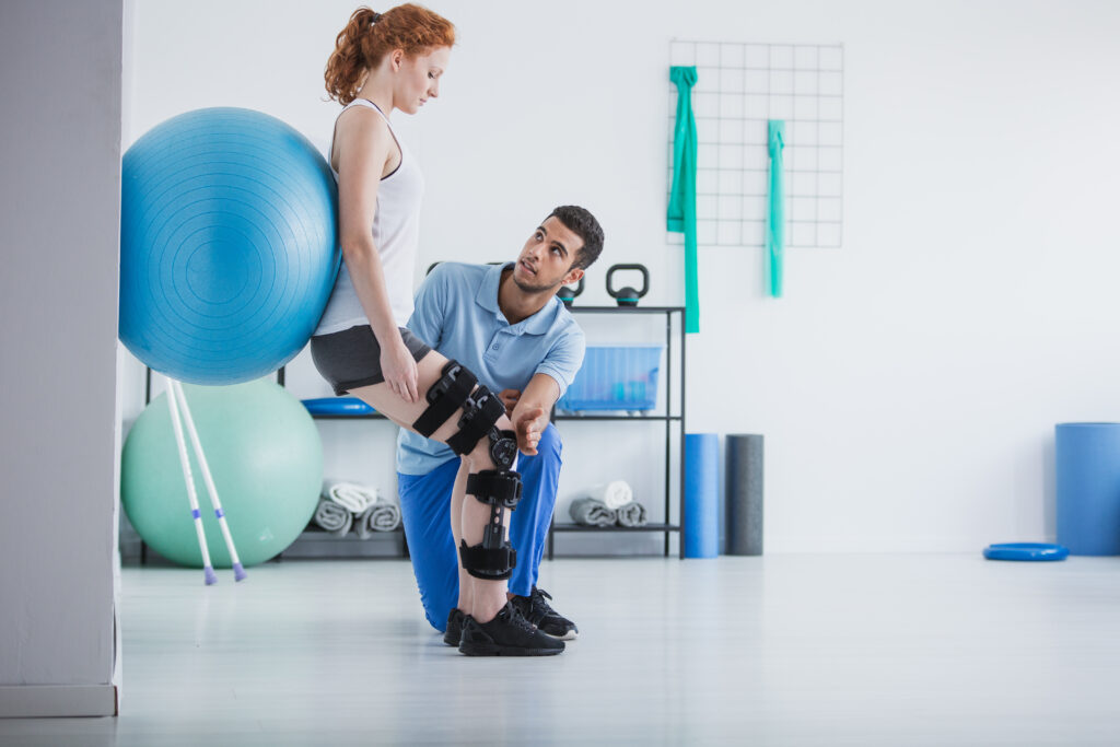 Post-operative physical therapy with a woman exercising on a ball under physiotherapist guidance.