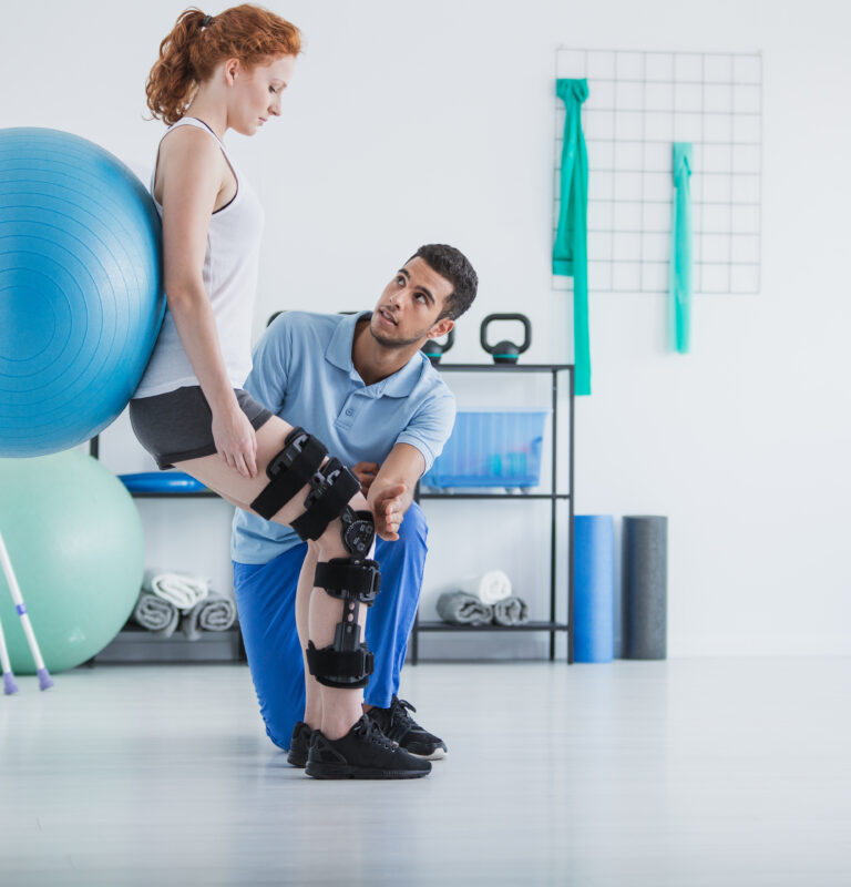 Post-operative physical therapy with a woman exercising on a ball under physiotherapist guidance.