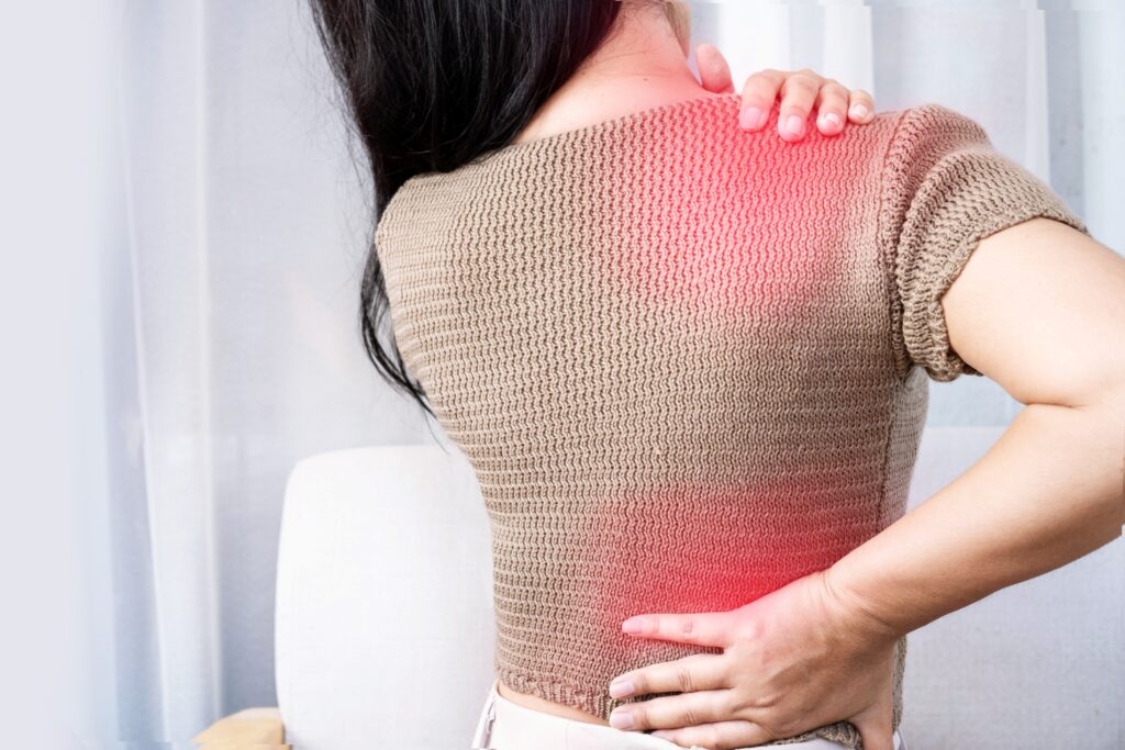 Woman experiencing shoulder and back pain spreading between areas, showing referred pain.