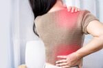 Woman experiencing shoulder and back pain spreading between areas, showing referred pain.