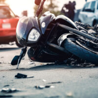 Damaged motorcycle lying on its side after a motorcycle accident on a roadway.