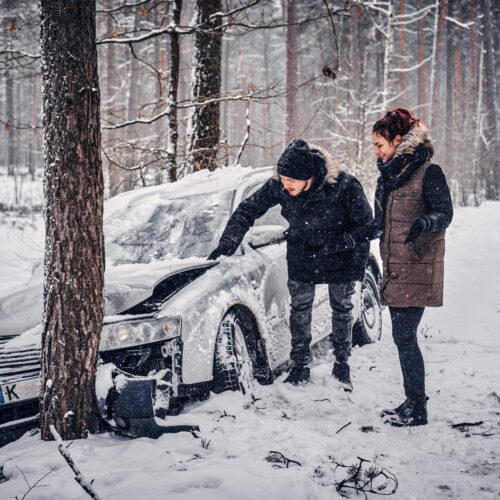 Vehicle that lost control on a snow-covered road and crashed into a tree during winter driving conditions