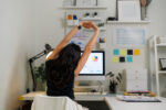 Remote worker stretching at a home office desk during a movement break while working from home