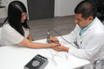 Healthcare provider performing an EMG test on a patient's arm to evaluate nerve and muscle function after injury