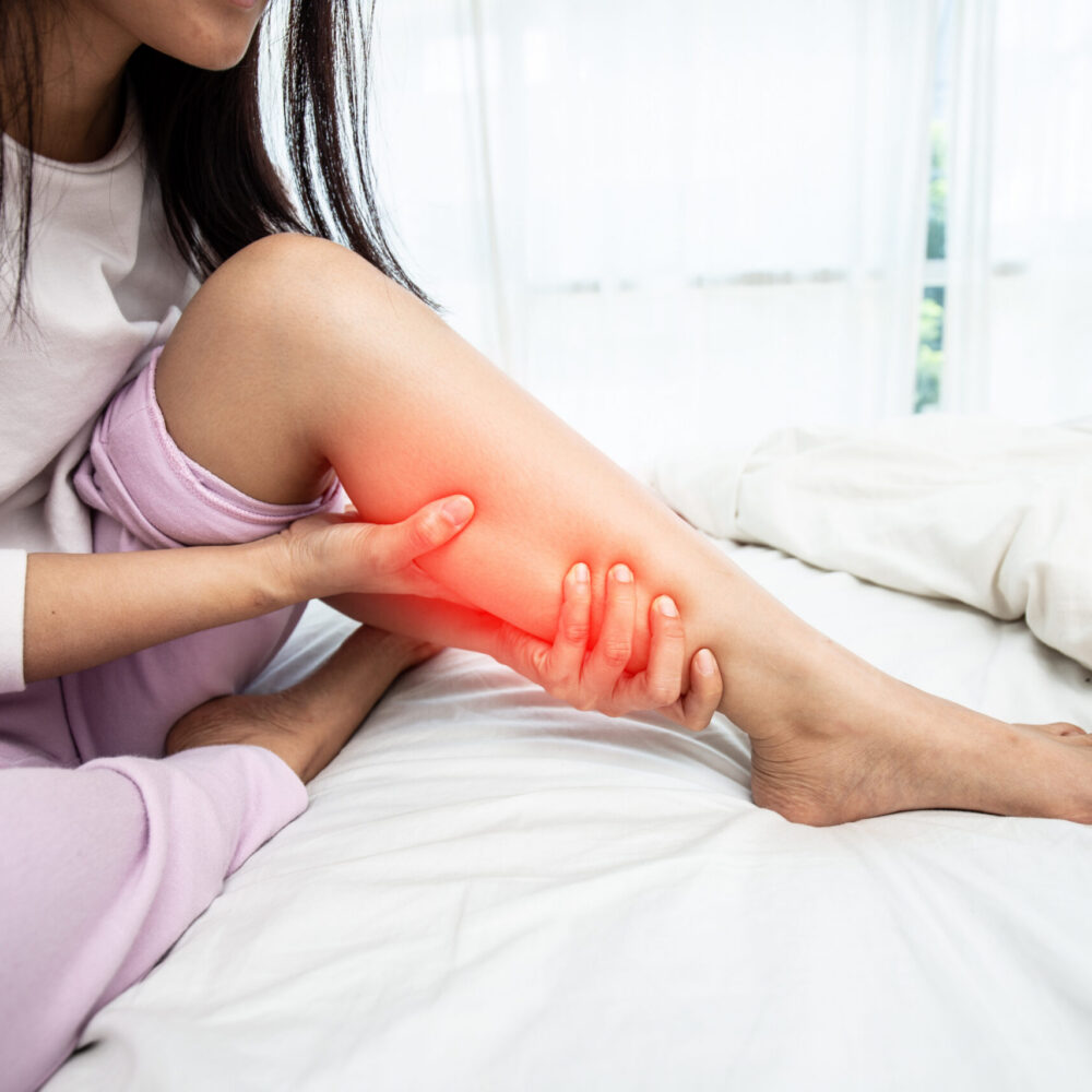 Person experiencing calf soreness from barefoot shoes transition pain