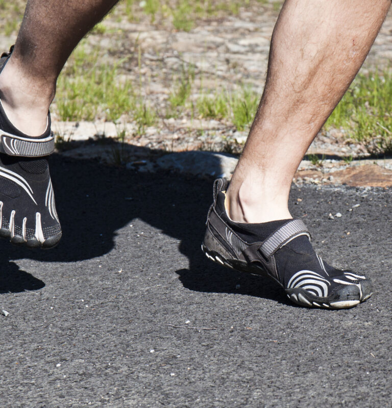 Person walking in barefoot shoes during a barefoot shoes transition