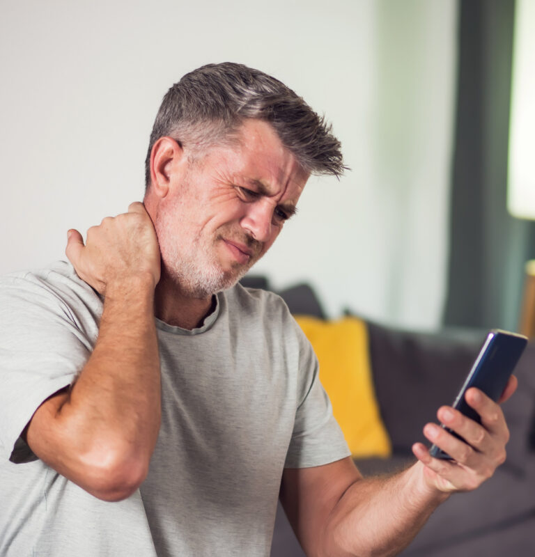 Man with neck pain looking at a smartphone while using ChatGPT for injury symptoms after an accident.