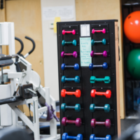 Rehabilitation gym with exercise equipment and free weights at the North Bronx Pain & Injury office in Bronx, NY.